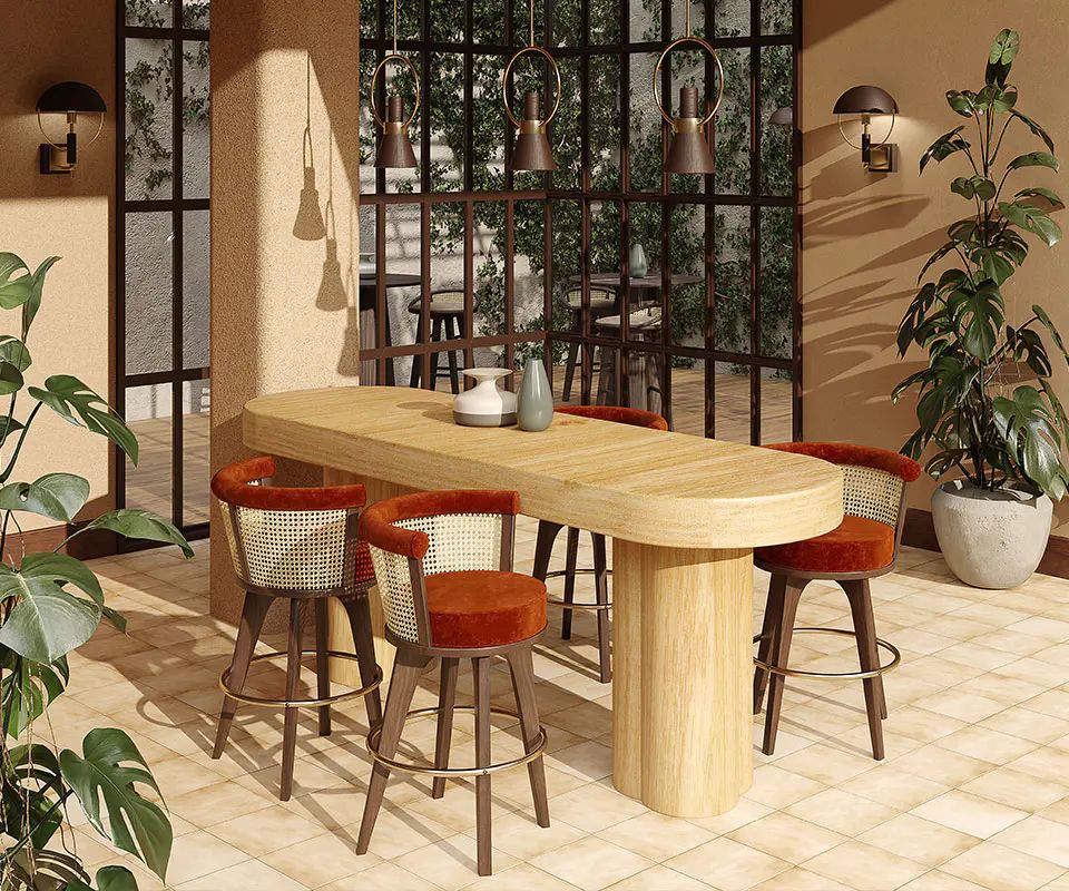 Oval timber counter with rattan and terracotta bar stools beside tall windows